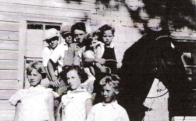 On Horse l-r: Harold Ross, Howard Hunt, Milo Ross, Josephine Sharp (arm only), Janelle England, Eddie Sharp.  In front l-r: Ruby Sharp, Lucille Maw, and Milo Riley Sharp.
